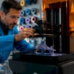 Technician adjusting 3D printer bridging filament