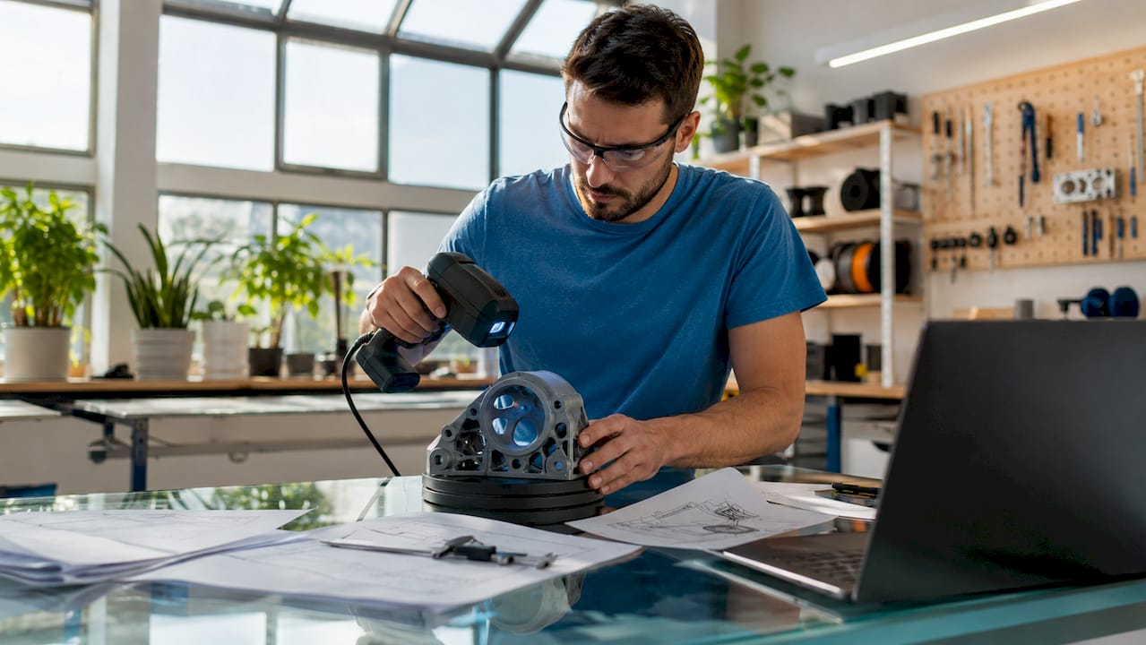 Engineer scanning mechanical part with 3D scanner
