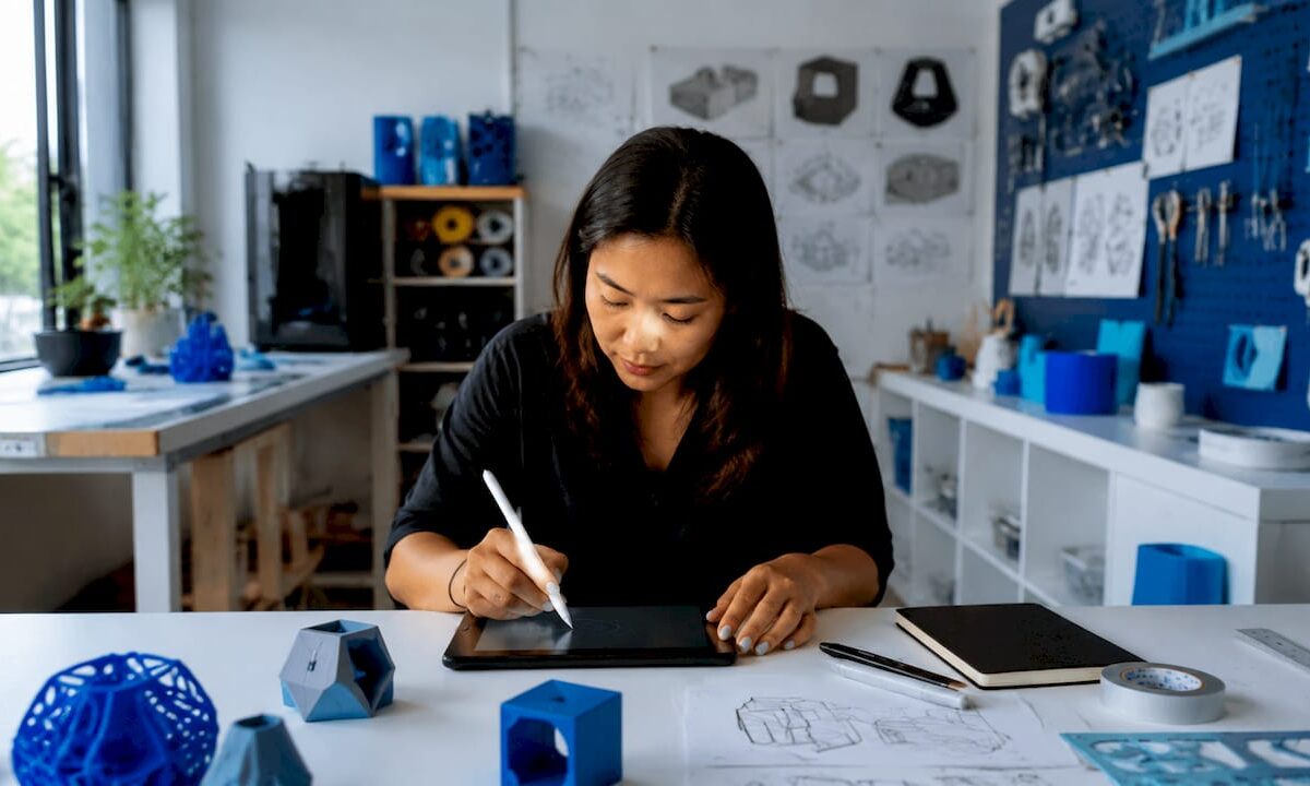 Designer sketching prototype goals at drafting table