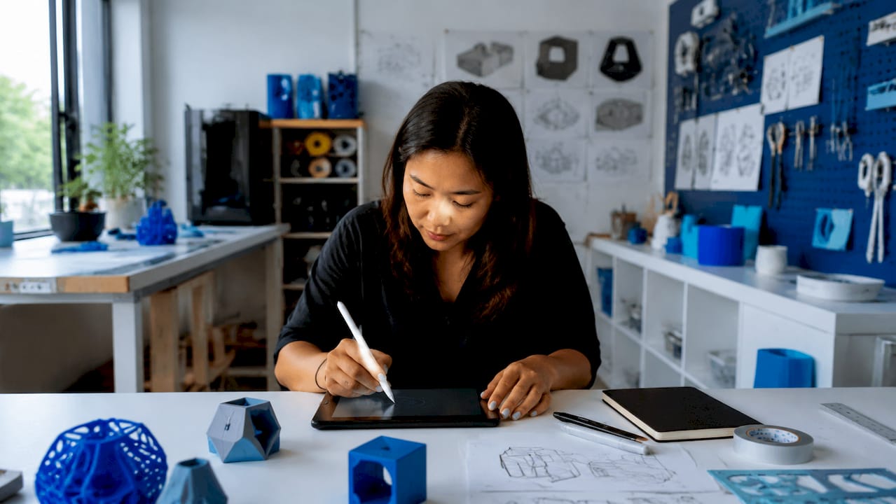 Designer sketching prototype goals at drafting table