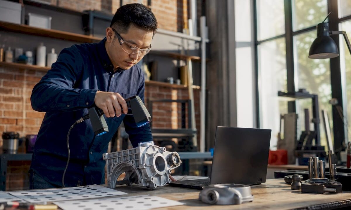 Engineer scanning mechanical part in lab