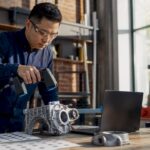Engineer scanning mechanical part in lab