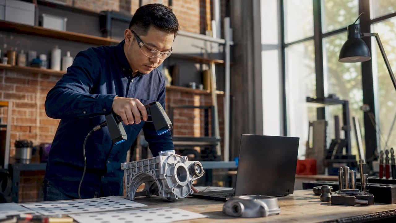 Engineer scanning mechanical part in lab