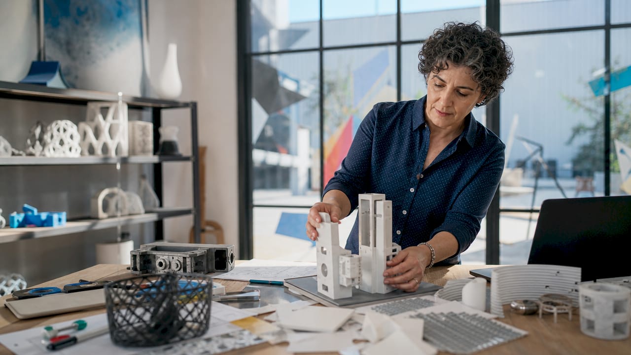 Female engineer reviewing 3D CAD model on monitor
