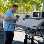 Technician 3D scanning aircraft part in workshop