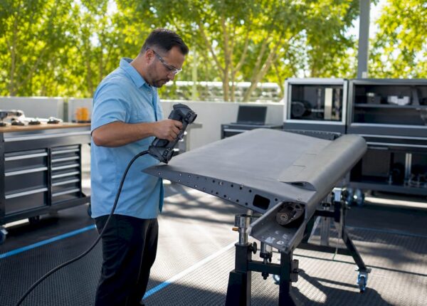 Technician 3D scanning aircraft part in workshop