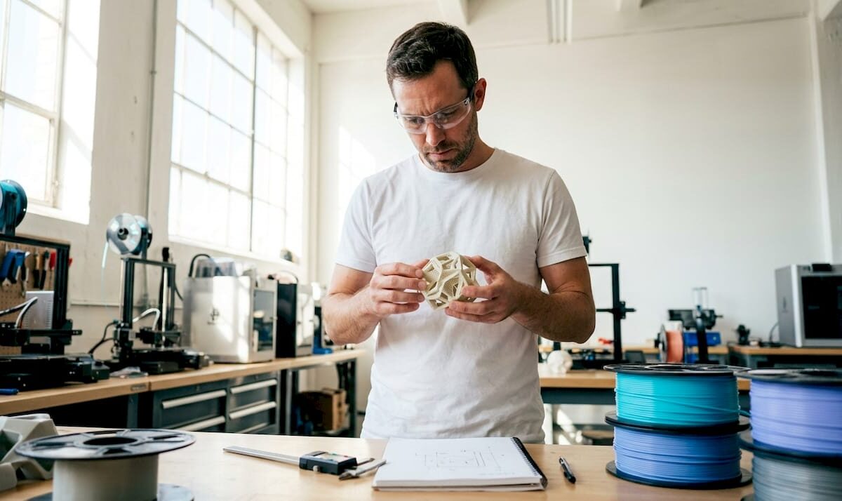 Engineer examining 3D printing model on laptop