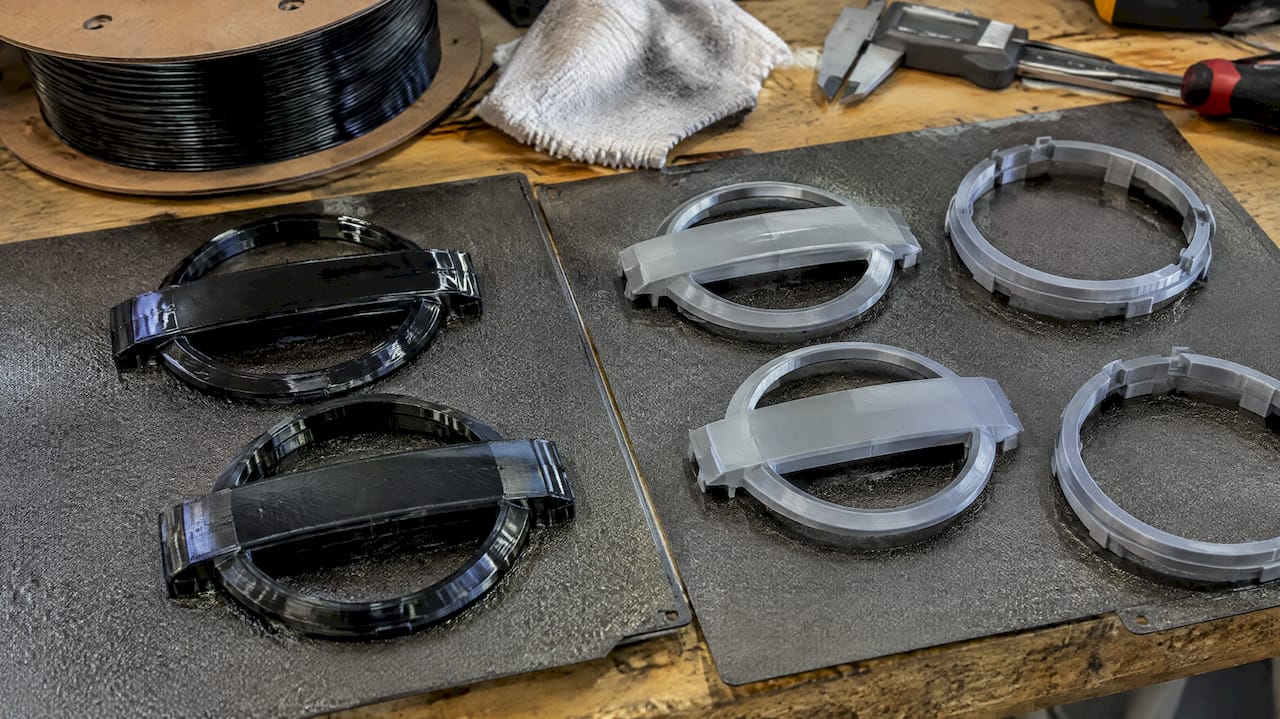 PETG and ASA emblem prototypes on build plates